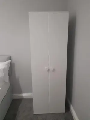 a white cabinet in a bedroom next to a bed at Hanwell House in Liverpool