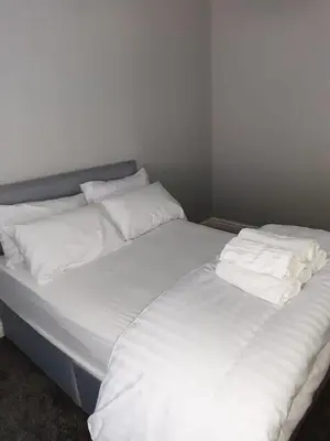 two beds with white sheets and pillows in a room at Hanwell House in Liverpool