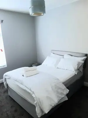 a white bed with white sheets and pillows at Hanwell House in Liverpool