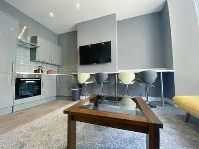 a living room with a coffee table and a tv at Chelsea Suite Sasco Apartments in Blackpool