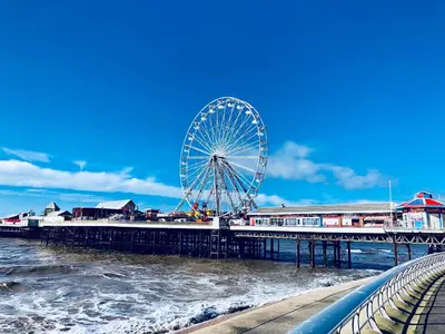 a ferris wheel on a pier next to the water at Kensington Suite Sasco Apartments in Blackpool