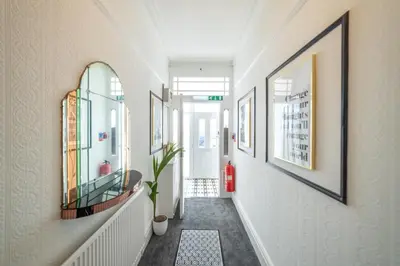a hallway with pictures on the walls at Charles Alexander Short Stay - Highcliffe Apartments in Cleveleys