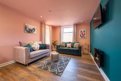 a living room with two couches and a flat screen tv at Charles Alexander Short Stay - Highcliffe Apartments in Cleveleys