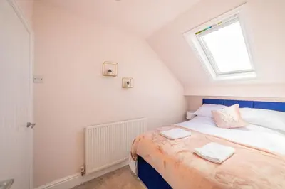 a small bedroom with a bed and a window at Charles Alexander Short Stay - Highcliffe Apartments in Cleveleys
