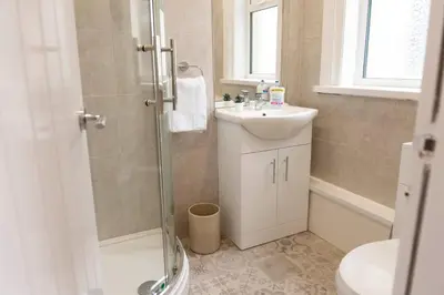 a bathroom with a shower and a sink and a toilet at Charles Alexander Short Stay - Highcliffe Apartments in Cleveleys
