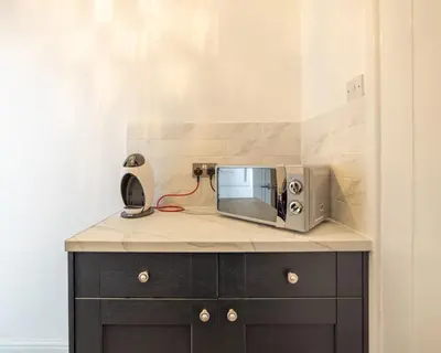 a microwave sitting on top of a counter at Charles Alexander Short Stay - Highcliffe Apartments in Cleveleys
