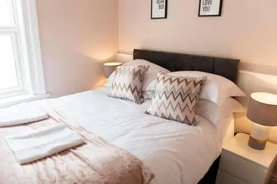 a bed with two pillows on it in a bedroom at Charles Alexander Short Stay - Highcliffe Apartments in Cleveleys