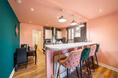 a kitchen and living room with a bar and chairs at Charles Alexander Short Stay - Highcliffe Apartments in Cleveleys