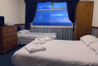 a hotel room with two beds and a window at Canasta Hotel in Blackpool