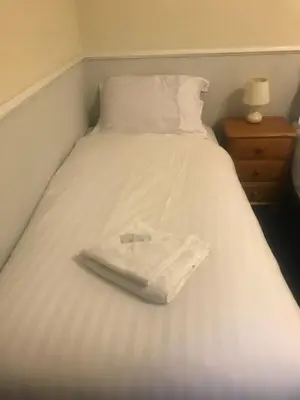 a white bed with a white towel on it at Canasta Hotel in Blackpool