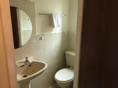 a bathroom with a toilet and a sink and a mirror at Canasta Hotel in Blackpool