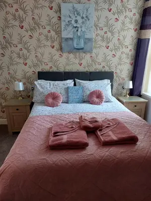a bedroom with a bed with two towels on it at PONDEROSA B&B with free onsite parking and breakfast included in Blackpool