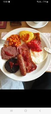 a plate of breakfast food with eggs beans and bacon at PONDEROSA B&B with free onsite parking and breakfast included in Blackpool