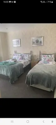 a bedroom with two beds and two pictures on the wall at PONDEROSA B&B with free onsite parking and breakfast included in Blackpool