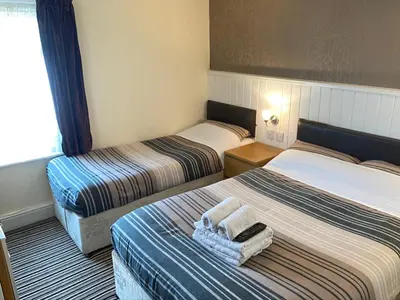 two beds in a hotel room with towels on them at Grange House Hotel in Blackpool
