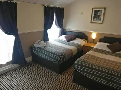 a hotel room with two beds and a window at Grange House Hotel in Blackpool