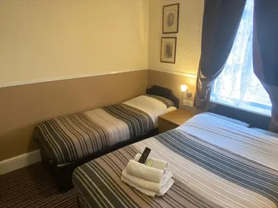 a hotel room with two beds and a window at Grange House Hotel in Blackpool