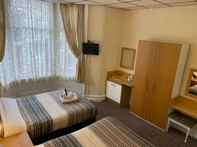 a hotel room with a bed and a sink at Grange House Hotel in Blackpool
