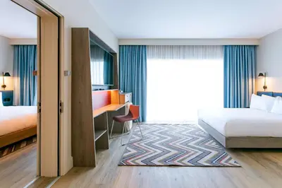 a hotel room with two beds and a desk at Hampton By Hilton Blackburn in Blackburn