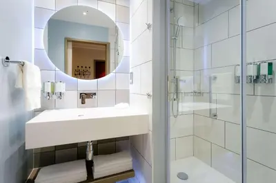 a white bathroom with a sink and a mirror at Hampton By Hilton Blackburn in Blackburn