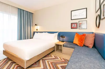 a bedroom with a bed and orange pillows at Hampton By Hilton Blackburn in Blackburn