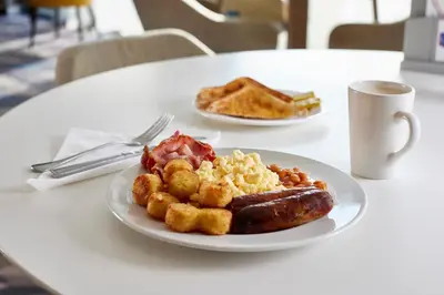 a plate of breakfast food on a table at Hampton By Hilton Blackburn in Blackburn