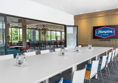 a conference room with a large white table and chairs at Hampton By Hilton Blackburn in Blackburn