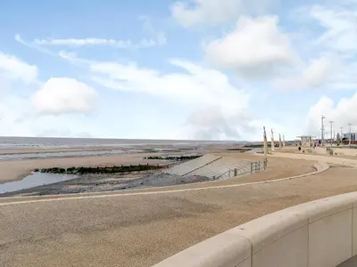 a road next to a beach with the ocean at Kays in Cleveleys
