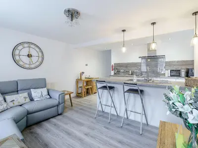 a living room with a couch and a kitchen at Kays in Cleveleys