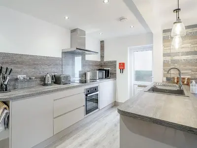 a kitchen with white cabinets and a counter top at Kays in Cleveleys