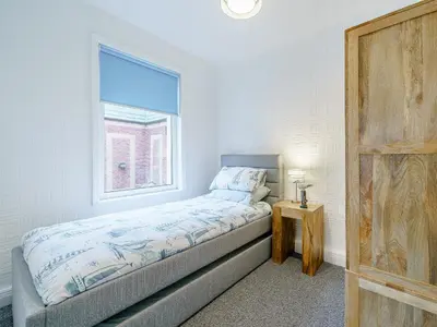 a small bedroom with a bed and a window at Kays in Cleveleys