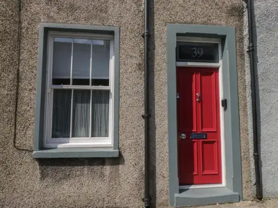 a building with a red door and a window at Number Thirty-Nine in Ulverston