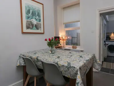 a dining room table with a vase of flowers on it at Number Thirty-Nine in Ulverston