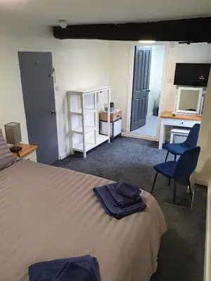 a bedroom with a bed with two chairs and a desk at Red Lion Rooms - Self Check In in Dalton in Furness