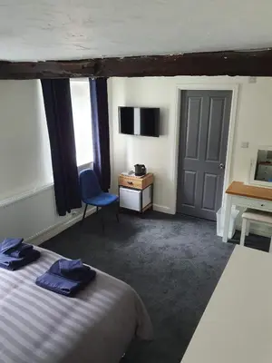 a bedroom with a bed and a desk and a chair at Red Lion Rooms - Self Check In in Dalton in Furness