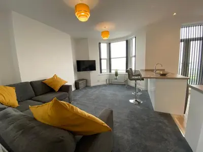 a living room with a couch and a table at Eden Escapes Serviced Apartments in Morecambe