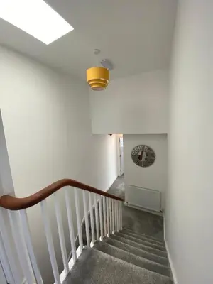 a hallway with a staircase with a light at Eden Escapes Serviced Apartments in Morecambe