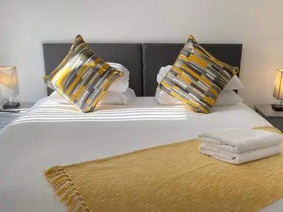 a bed with two pillows and a blanket on it at Eden Escapes Serviced Apartments in Morecambe