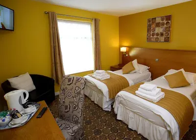 a hotel room with two beds and a window at The Birley Arms Hotel in Preston