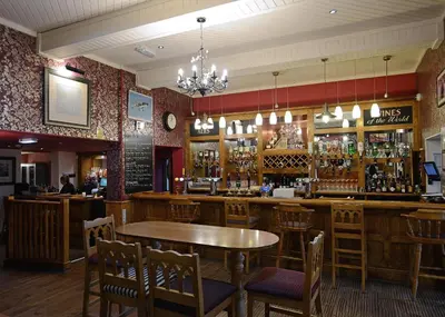 a bar with a table and chairs in a restaurant at The Birley Arms Hotel in Preston