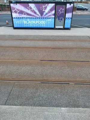 a set of stairs with a sign on the side of a street at Sea-front Apartment home-from-home in Blackpool