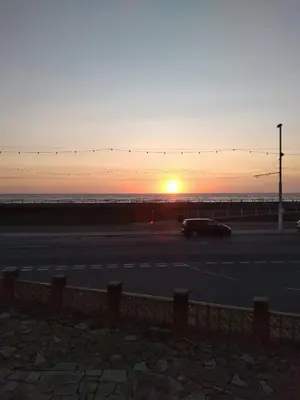 a car parked in a parking lot with the sunset at Sea-front Apartment home-from-home in Blackpool
