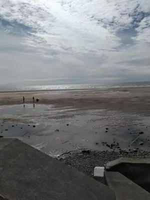 a beach with two people standing on the sand at Sea-front Apartment home-from-home in Blackpool