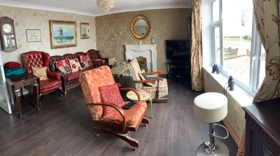 a living room with couches and chairs and a mirror at Sea-front Apartment home-from-home in Blackpool