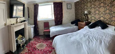 a hotel room with two beds and a fireplace at Sea-front Apartment home-from-home in Blackpool