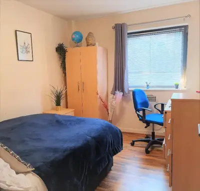 a bedroom with a bed and a desk and a chair at Two-bedroom ground-floor apartment Self check-in in Liverpool