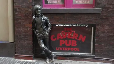 a statue of a man standing in front of a sign at Two-bedroom ground-floor apartment Self check-in in Liverpool
