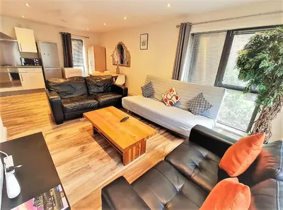 a living room with leather furniture and a table at Two-bedroom ground-floor apartment Self check-in in Liverpool