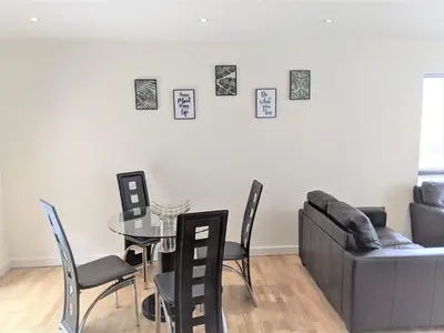 a living room with a glass table and a couch at Two-bedroom ground-floor apartment Self check-in in Liverpool