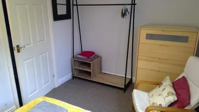 a bedroom with a bed and a swing at Cosy house for business travel and pleasure in Bickershaw